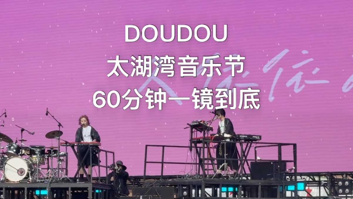 音乐节舞台上的 DOUDOU，身后是大屏幕与密集的观众